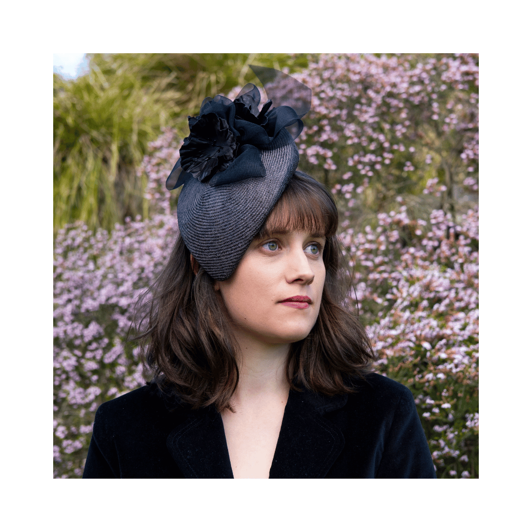 Model wearing a charcoal teardrop percher with handmade charcoal blooms and sheer French mousseline ribbon bows.
