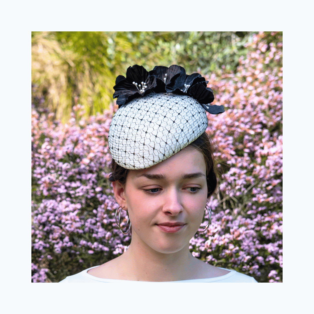 Model wearing a cream and ebony beret by Jo Ramsay Millinery with a pink floral background